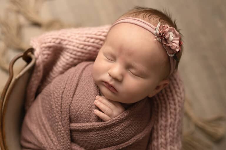 newborn girl wrapped in a bucket
