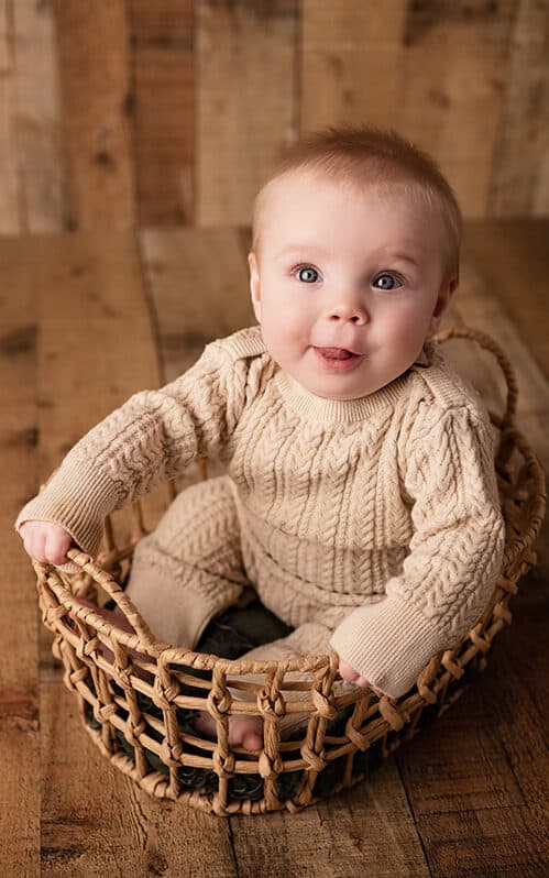 baby boy milestone photos in a basket