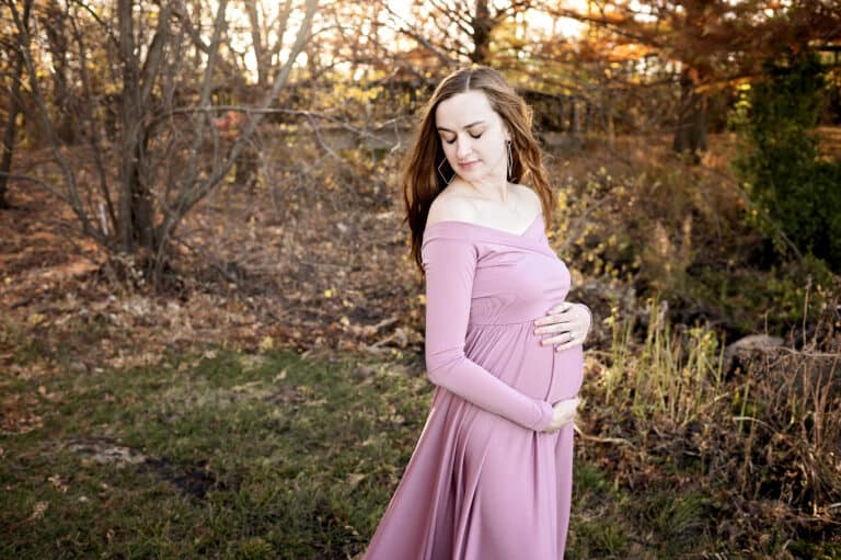 expecting mother breathes in and holds her baby bump