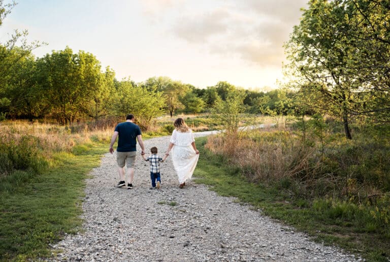family walking down a path at sunset