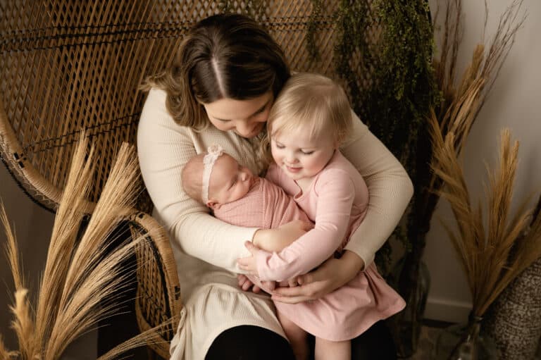 mother with little girl hug new baby sister