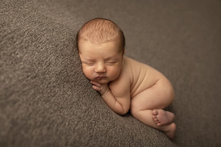 baby boy posed on fabric for newborn photography