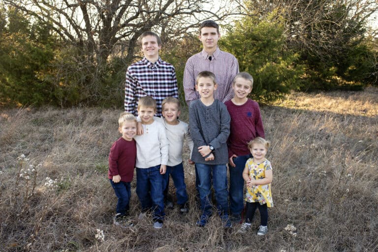 large family photo of siblings in a field