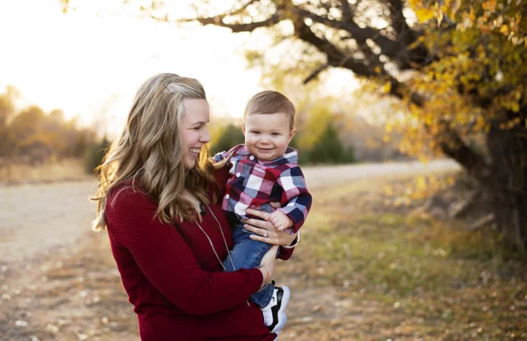 mother holds her one year old son for fall family photos