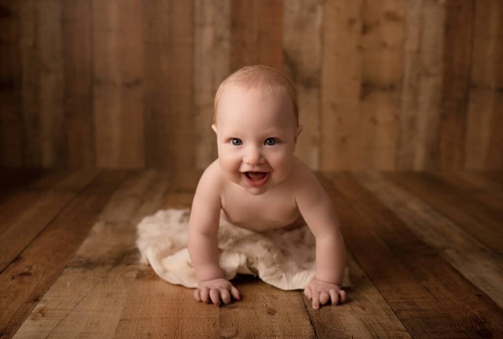 newton ks milestone photography baby boy crawling on wood floor