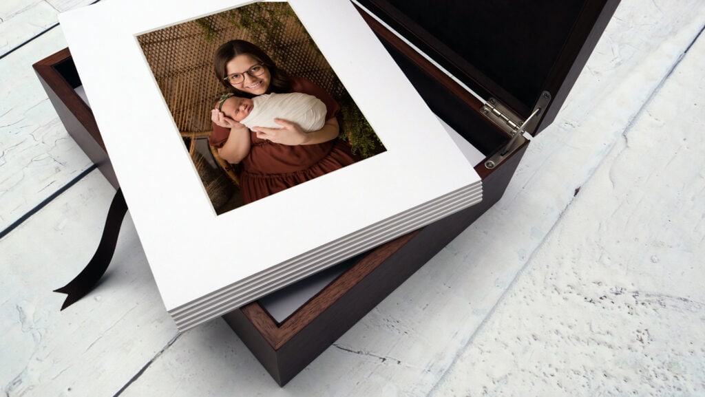 matted prints sitting in a walnut display box
